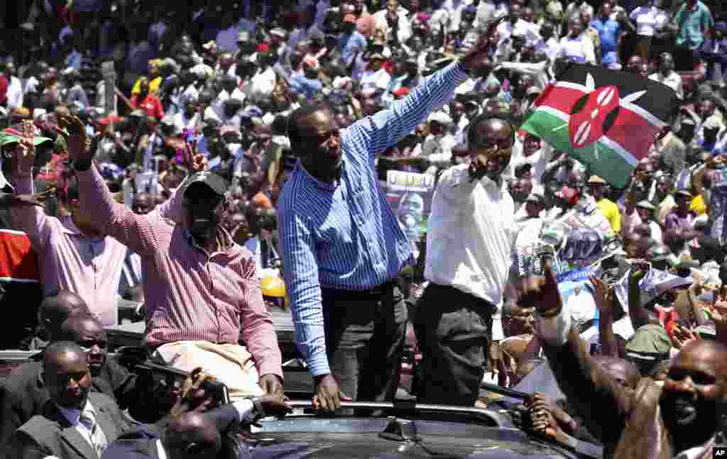 Wazir wa zamani wa elimu Kenya &nbsp;William Ruto, kushoto, Naibu Waziri Mkuu Uhuru Kenyatta, kati, na makamu rais Kalonzo Musyoka, kulia, wakiwapungia mkono maelfu ya rais kwenye uwanja wa Uhuru Park, Kenya, Ap