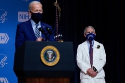 President Joe Biden speaks during a visit to the National Institutes of Health, Feb. 11, 2021, in Bethesda, Md. Dr. Anthony Fauci, director of the National Institute of Allergy and Infectious Diseases, listens at right.
