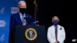 President Joe Biden speaks during a visit to the National Institutes of Health, Feb. 11, 2021, in Bethesda, Md. Dr. Anthony Fauci, director of the National Institute of Allergy and Infectious Diseases, listens at right.