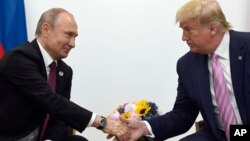 Rusya Cumhurbaşkanı Putin ile ABD'nin eski Başkanı Trump 28 Haziran 2019'da Japonya'nın Osaka kentinde düzenlenen G-20 zirvesindeki görüşmeleri sırasında el sıkışıyor