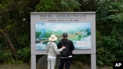 South Korean visitors look at a map which shows a border area of two Koreas with a railroad line between Munsan city in south and Kaesong in north, at the Imjingak Pavilion in Paju, South Korea, near the border with North Korea, Oct. 14, 2024.