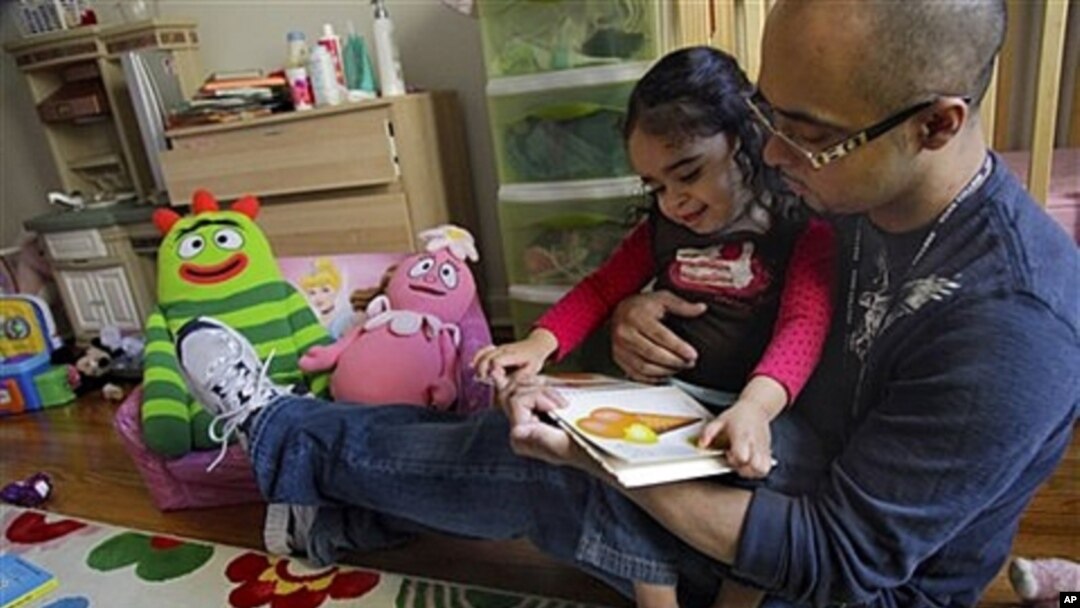 Christopher Astacio membaca bersama putrinya Cristina, 2, yang didiagnosa memiliki autisme ringan.