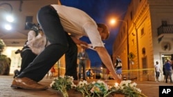 Charlottesville resident Elliot Harding lights a candle as he places flowers and a stuffed animal at a makeshift memorial for the victims after a car plowed into a crowd of people peacefully protesting a white nationalist rally earlier in the day in Charlottesville, Va., Aug. 12, 2017.