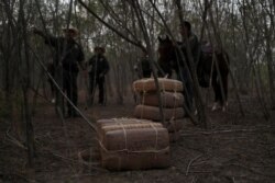 FILE - Border patrol agents surround what they said was about 140 pounds of marijuana which was abandoned by smugglers in La Joya, Texas, Nov. 7, 2019.