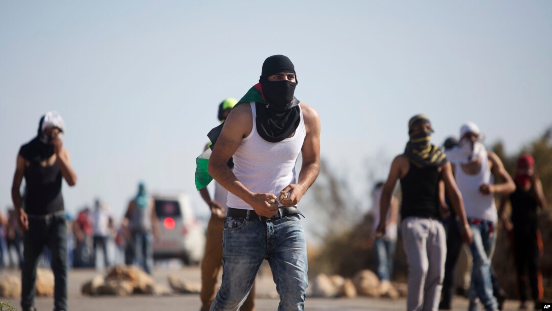 Demonstran Palestina melemparkan batu ke arah pasukan keamanan Israel dalam aksi protes atas tewasnya seorang warga Palestina di Duma dekat Nablus, Tepi Barat (8/8).