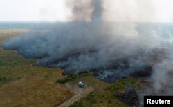 An aerial view shows smoke rising over a deforested plot of the Amazon jungle in Porto Velho, Rondonia State, Brazil, Aug. 27, 2019.