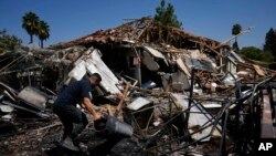 A man works next to a destroyed home after rockets struck in Katzrin, in the Israeli-annexed Golan Heights, on Aug. 21, 2024. Lebanon's Hezbollah launched more than 50 rockets, hitting a number of private homes in the area.