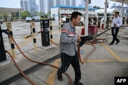 FILE - In this picture taken on October 18, 2023, a taxi driver prepares to charge his electric vehicle at Antuoshan charging station in Shenzhen, China's southern Guangdong province.