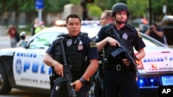 Police keep watch during a protest Friday, July 29, 2016, in Dallas. The event was organized by the same activist group that organized the July 7, protest that ended with the fatal shooting of five police officers. (AP Photo/Ron Jenkins)