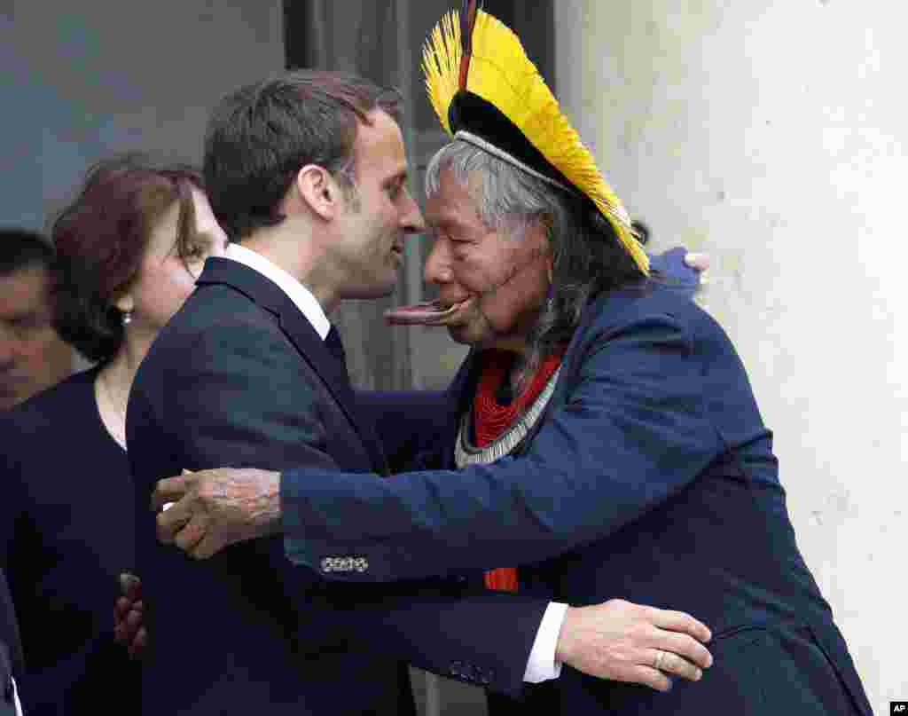 Kayapo tribal leader Raoni Metuktire, right, hugs French President Emmanuel Macron, after a meeting at the Elysee Palace, in Paris.