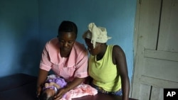 Margaret, MCHaid at Pendembu clinic examines a new born in Kallahun, Sierra Leone