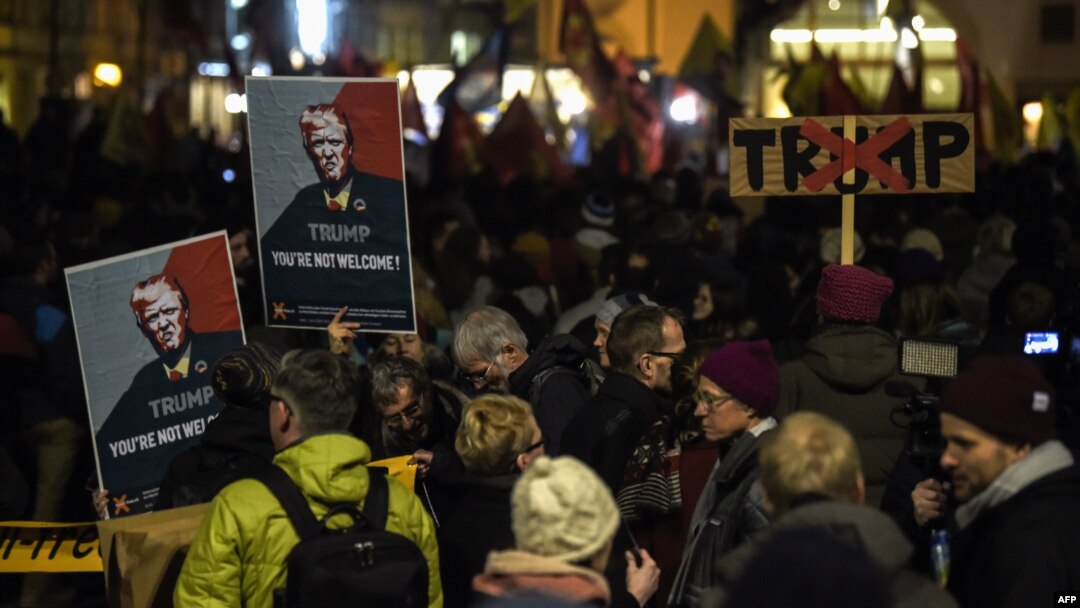 FILE - People hold up banners with images of U.S. President Donald Trump as they rally against his attendance of the Davos World Economic Forum, in central Zurich, Switzerland, Jan. 23, 2018. A Socialist youth group has been authorized Thursday to hold a similar rally in Davos.