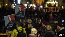 FILE - People hold up banners with images of U.S. President Donald Trump as they rally against his attendance of the Davos World Economic Forum, in central Zurich, Switzerland, Jan. 23, 2018. A Socialist youth group has been authorized Thursday to hold a similar rally in Davos.