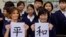 La primera dama de EE.UU. Melania Trump y Akie Abe, esposa del primer ministro japonés Shinzo Abe, muestran una imagen de caligrafía japonesa que hicieron durante una clase de niños de cuarto grado en la escuela primaria Kyobashi Tsukiji de Tokio, Japón. Nov.. 6 de 2017.