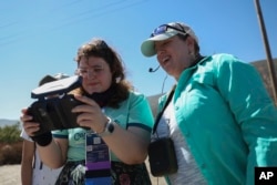 Grace Telfer, left, and Anita Marshall, a geoscience education researcher at the University of Florida, operate a drone Thursday, Sept. 26, 2024, in San Bernadino, Calif. (AP Photo/Ryan Sun)