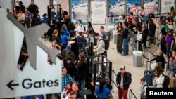 FILE PHOTO: Travelers wait at John F. Kennedy International Airport in New York