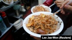 Siswa makan nasi di warung pinggir jalan di Goshichon, di Seoul 13 Desember 2012. (Foto: REUTERS/Lee Jae-Won)