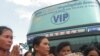 A Cambodian People's Party poster hangs on a wall outside a business as a woman offers prayers to Buddhist Monks, file photo. At least 10 parties have registered for elections, which will be held across 1,633 communes next month. 