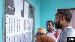 Voters check the voter list at a polling station in Mitsoudje on Jan. 12, 2025, during the Comorian parliamentary election. 