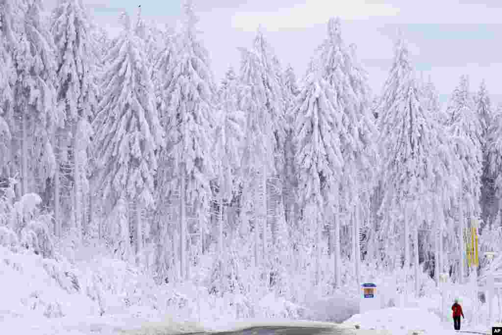 A man walks through a snow-covered landscape in Oberhof, Germany.