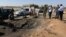 FILE- Army personnel look at the site of an explosion at an army checkpoint in Barsis, east of Benghazi, Libya, June 12, 2014.
