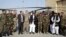 Afghanistan President Ashraf Ghani, center, poses with U.S. and local military officials during a ceremony after receiving two Black Hawk helicopters from the U.S. government, at Kandahar Air Field, Afghanistan, Oct. 7, 2017.
