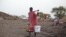 A woman carries water from a water hole near Jamam refugee camp in South Sudan's Upper Nile State, March 10, 2012.