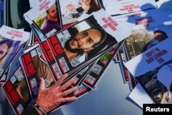 FILE - A person holds posters as families of hostages protest the delivery of humanitarian aid to Gaza, demanding immediate release of hostages kidnapped on October 7, in Kerem Shalom, Israel, January 25, 2024.