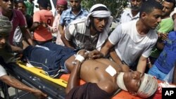 People carry an injured protester after clashes with police in Aden Apr 13 2011