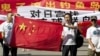 Chinese protesters hold banners reading "Declare war against Japan" and "Japan get out of Diaoyu islands" during a protest outside the Japanese Embassy in Beijing Aug. 15, 2012. 