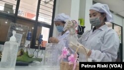 Mahasiswa Fakultas Farmasi Ubaya sedang memasukkan hand sanitizer bentuk gel ke dalam botol kemasan. (Foto: VOA/ Petrus Riski)