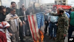 FILE - Protesters burn a representation of the U.S. flag during a rally against the U.S.'s decision to designate Iran's powerful Revolutionary Guards as a foreign terrorist organization, in Tehran, April 12, 2019. 