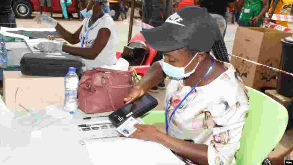 A poll worker verifies a voter&#39;s ID on election day in Accra, Ghana, Dec. 7, 2020. (Photo: Peter Clottey, Issah Ali / VOA)