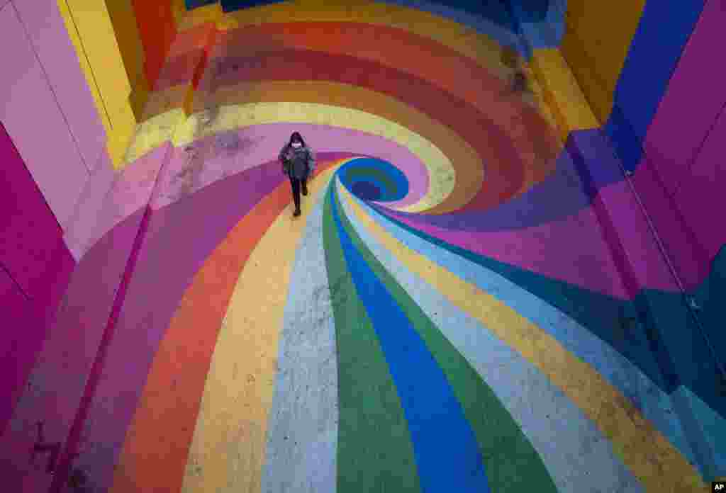 A woman walks along the rainbow-colored Paseo Bandera in Santiago, Chile, April 27, 2021, which is empty due to the coronavirus pandemic.