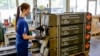 FILE - An employee of German armaments company Rheinmetall packs boxes of ammunition for Leopard battle tanks that will be delivered to Ukrainian forces, at its facility in Unterluess, Germany, June 6, 2023. 