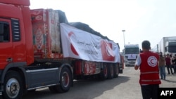 A volunteer from the Egyptian Red Crescent looks on as a convoy of lorries carrying humanitarian aid crosses to the Gaza Strip on Oct 22, 2023.