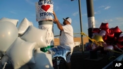 En esta foto de archivo del 6 de agosto de 2019, un hombre coloca un cartel de "El Paso Strong" (Fuerza El Paso) en un monumento improvisado a las víctimas de la masacre de El Paso, Texas. (AP Foto/John Locher)