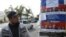 A local resident looks at election campaign posters, which are on display in the village of Vorontsovka near the capital Bishkek, Kyrgyzstan, Oct. 1, 2015.