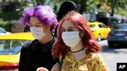 Young people wearing face masks to protect against the spread of coronavirus, walk in Ankara, Turkey, Friday, June 26, 2020. Turkish authorities have made the wearing of masks mandatory in most of the country to curb the spread of COVID-19 following…