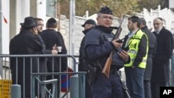 An armed police officer stands guard at the entrance of the Ozar Hatorah Jewish school in Toulouse, southwestern France, March 20, 2012.