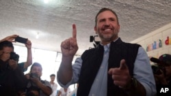 Roberto Arzú, candidato presidencial de la coalición de los partidos PAN y Podemos, muestra su dedo manchado de tinta a la prensa después de emitir su voto durante las elecciones generales en la Ciudad de Guatemala, el domingo 16 de junio de 2019.