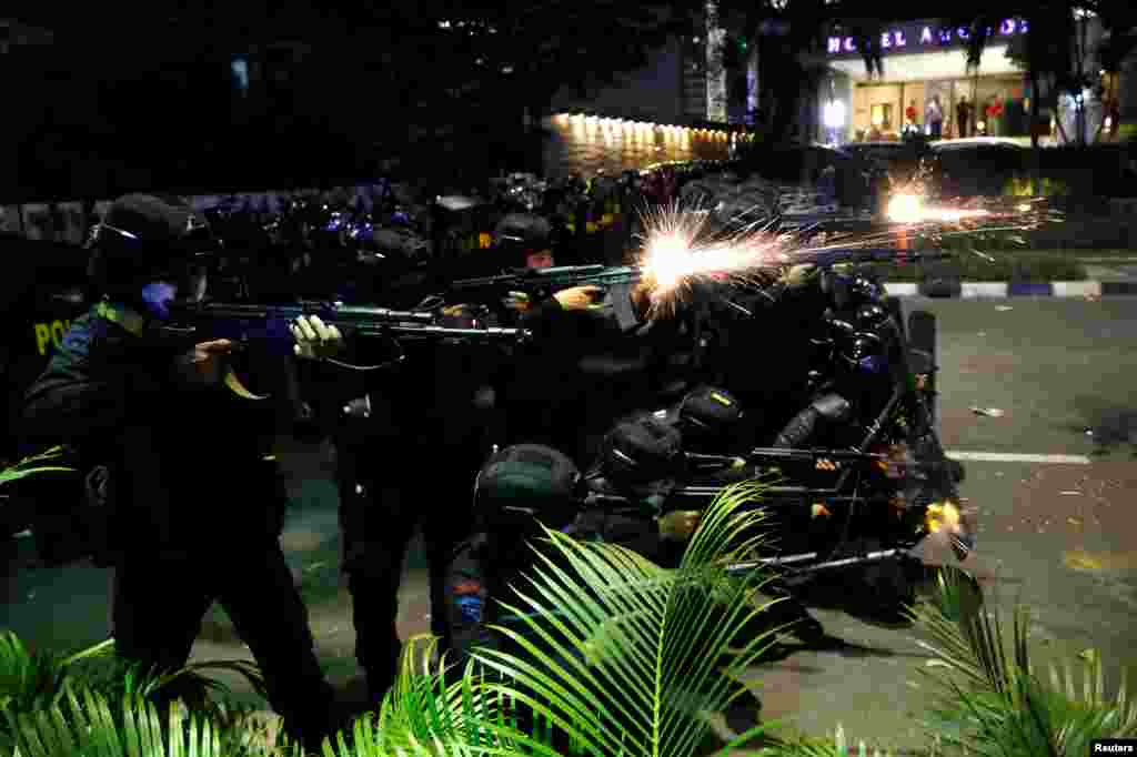 Anggota Brimob menembakkan senjata saat terjadi bentrokan dengan demonstran di Jakarta, Rabu dini hari (22/5) di Jakarta. (Foto: Willy Kurniawan/Reuters). 