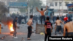 Iraqi demonstrators clash with Iraqi security forces during a protest over poor public services in Baghdad