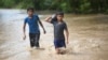 ARCHIVO: Dos niños vadean un área inundada en Pazos, Guatemala, después del paso del huracán Eta el 6 de noviembre de 2020.