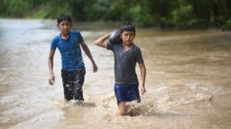 ARCHIVO: Dos niños vadean un área inundada en Pazos, Guatemala, después del paso del huracán Eta el 6 de noviembre de 2020.