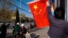 Tibetan hangs a Chinese national flag outside a residential building in Lhasa, March 28, 2009.