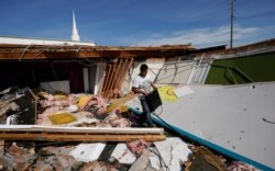 FILE - Benjamin Luna helps recover items from the children's wing of the First Pentecostal Church that was destroyed by Hurricane Laura, Aug. 27, 2020, in Orange, Texas.