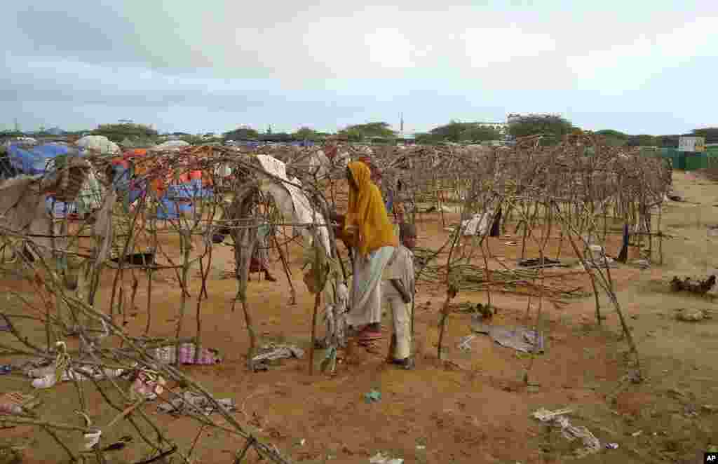 Displaced Somali women take down their makeshift shelters as they prepare to move from Mogadishu's Badbado camp where a fire fight between Somali government forces and militiamen looting food aid left at least seven people dead, Friday Aug. 5, 2011. (AP)