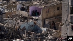 FILE—Palestinians look at the destruction after an Israeli strike on residential buildings and a mosque in Rafah, Gaza Strip, February 22, 2024.