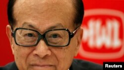 Chinese tycoon Li Ka-shing in front of Hutchison Whampoa company logo, Hong Kong, March 26, 2013.